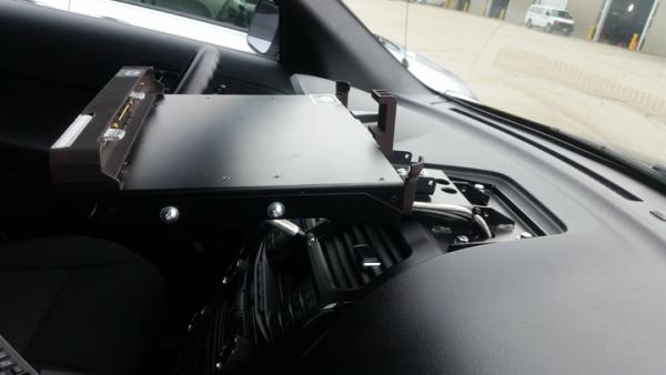 Close-up of the dash mount plate bolted to the passenger side of the dash with the dock body at left