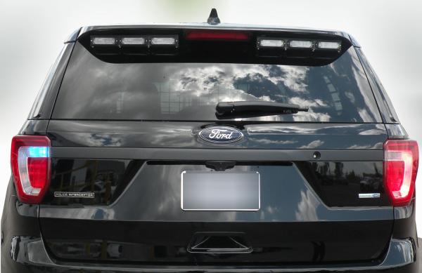 Modules switched off under the rear spoiler of a black Explorer, showing the clear lenses in their bracket