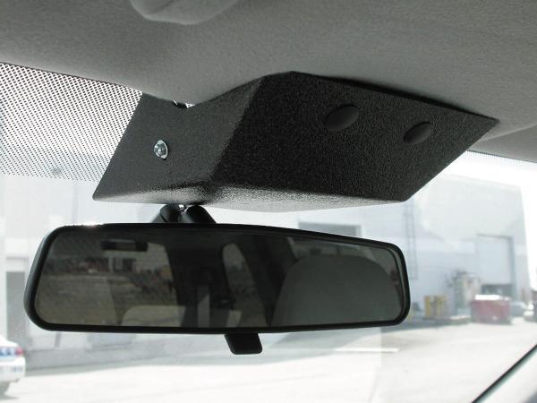 Light bracket installed on the windshield header directly above a vehicle rear-view mirror, seen from inside